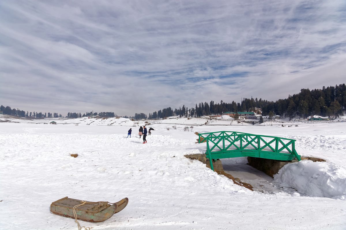 Visitors walking across the snowfield at Gulmarg