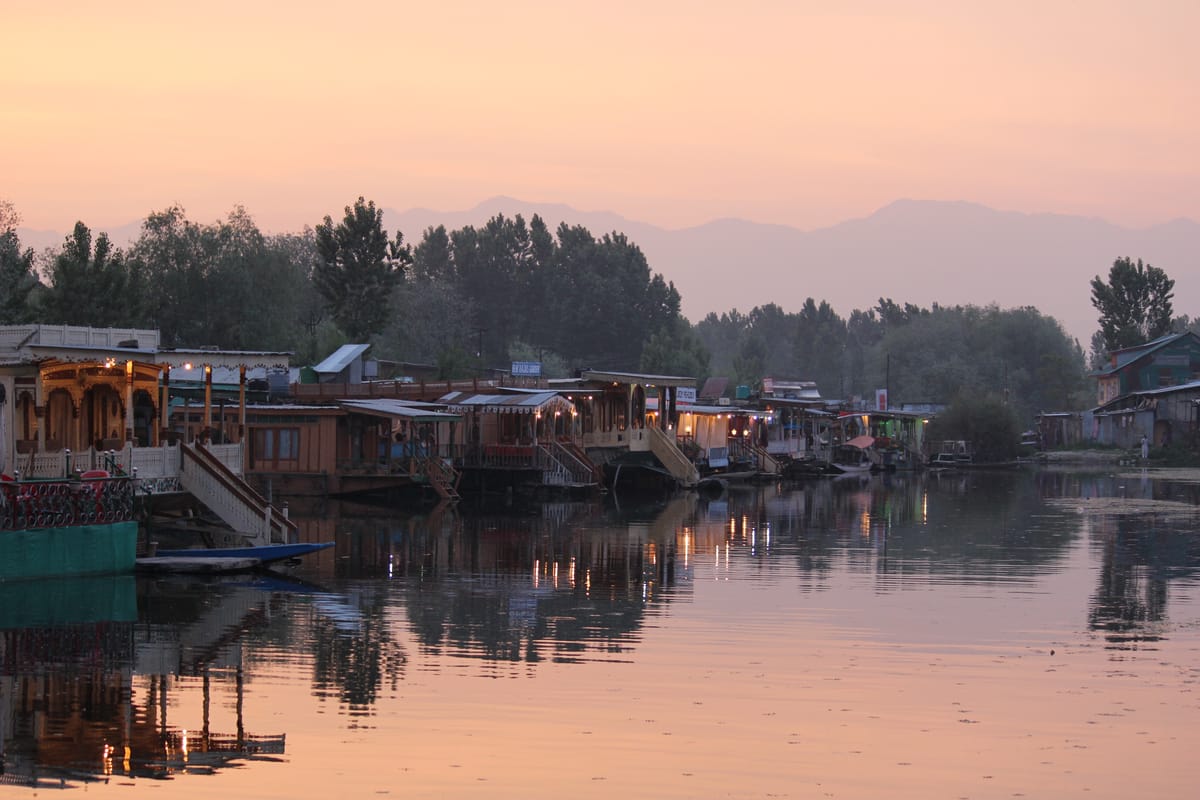 Carved houseboats reflected on Dal Lake at dusk