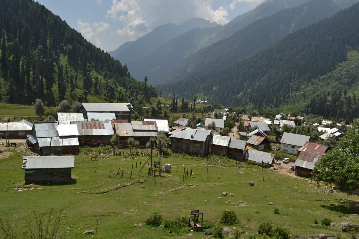 Aru village and meadows surrounded by forested mountains